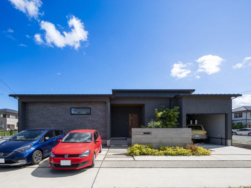 三重で注文住宅ならアイデザインホーム｜アイデザインホームの実例集｜ダークトーンのグレーを基調とした落ち着きのある外観。雨風からお気に入りのヴィンテージカーを守れるよう、シャッター付きのビルドインガレージを設けています